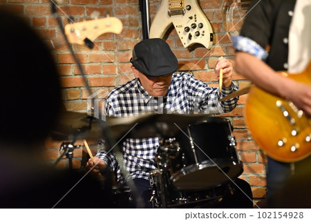Blues band drummer playing in a live house 102154928