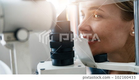 Close up of a patient's vision check at an opticians shop or ophthalmology clinic 102160433