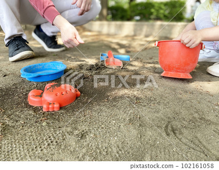 Parents and children playing in the sandbox Parents and children playing in the sandbox 102161058