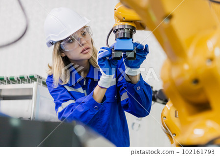 female technician engineer checking automation robotics at industrial modern factory. female technician engineer checking automation robotics at industrial modern factory. 102161793