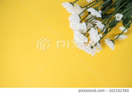Top view of a yellow table with a mockup of empty notebooks with a bouquet of roses. Place for text 102162368