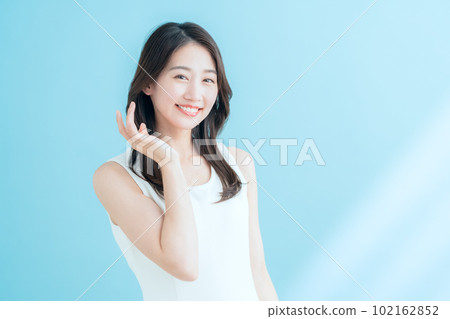 A young woman doing skin care on a blue background where the sun shines 102162852