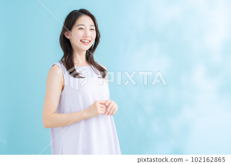 A young woman doing skin care on a blue background where the sun shines 102162865