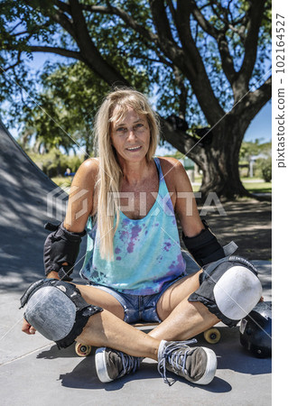 Smiling middle age woman portrait with skateboard in sport lifestyle at summer sunny day. Street urban sporty lifestyle concept. Smiling middle age woman portrait with skateboard in sport lifestyle at summer sunny day. Street urban sporty lifestyle concept. 102164527