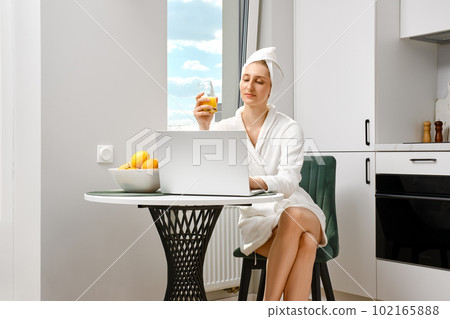 Young woman checking mail while having breakfast 102165888