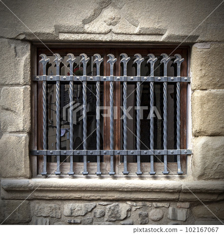 metal grating on an old window in a stone building metal grating on an old window in a stone building 102167067