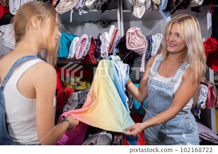 In the tailor's workshop, the designer and her assistant lay out the colorful fabric. 102168722