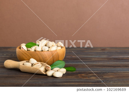 Fresh healthy Pistachios in bowl on colored table background. Top view Healthy eating concept. Super foods Fresh healthy Pistachios in bowl on colored table background. Top view Healthy eating concept. Super foods 102169689
