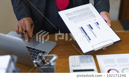 Business analysis concept, Senior businessman reading business chart and typing data on laptop Business analysis concept, Senior businessman reading business chart and typing data on laptop 102171248