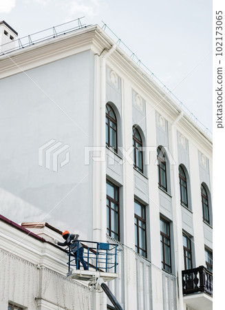 Construction worker in lift bucket paint Construction worker in lift bucket paint 102173065