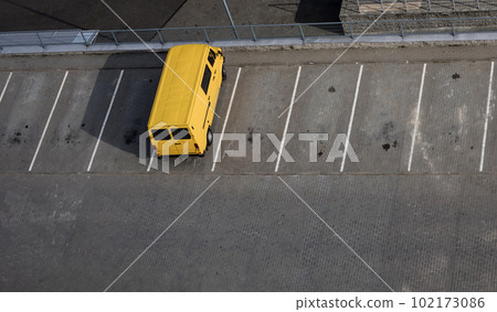 yellow van is standing in an empty parking lot 102173086