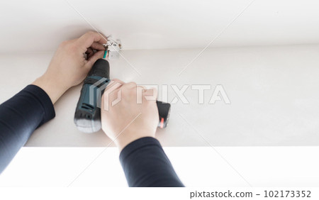 Handyman using a cordless screwdriver. 102173352
