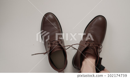 cleaning brown leather boots on white background cleaning brown leather boots on white background 102174739