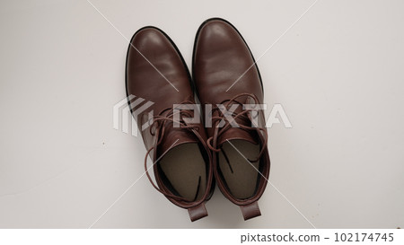 cleaning brown leather boots on white background 102174745
