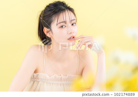 Young woman doing skin care with yellow back Young woman doing skin care with yellow back 102174889