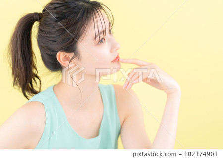 Young woman doing skin care with yellow back Young woman doing skin care with yellow back 102174901