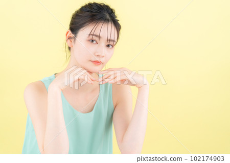 Young woman doing skin care with yellow back Young woman doing skin care with yellow back 102174903
