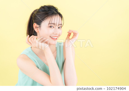 Young woman doing skin care with yellow back Young woman doing skin care with yellow back 102174904