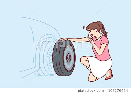 Woman looks at punctured car tire trying to call for help to change tire or haul automobile 102176434