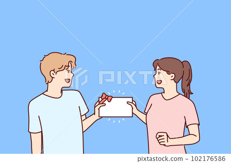 Man and woman with gift certificate in hands rejoice at receiving invitation card 102176586