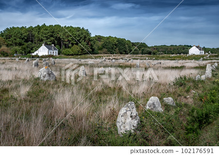 Ancient Stone Field Alignements De Menhir Carnac With Neolithic Megaliths And Old Cottage In Brittany, France Ancient Stone Field Alignements De Menhir Carnac With Neolithic Megaliths And Old Cottage In Brittany, France 102176591