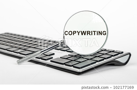 Copywriting word though magnifying glass on computer keyboard 102177169