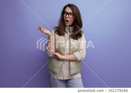 young brunette businesswoman with poor eyesight wearing glasses on studio background with copy space 102179266