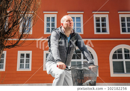 Portrait of a handsome hipster man. A man in a big city cycling down the street on a bicycle, a life style concept Portrait of a handsome hipster man. A man in a big city cycling down the street on a bicycle, a life style concept 102182256