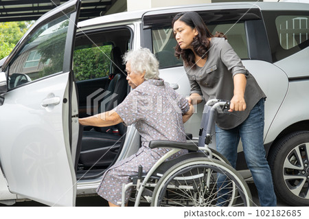 Caregiver help and support asian elderly woman sitting on wheelchair prepare get to her car to travel in holiday. Caregiver help and support asian elderly woman sitting on wheelchair prepare get to her car to travel in holiday. 102182685