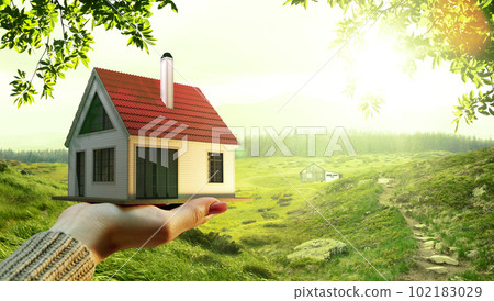 Female holding small 3D model of nice house over green field, nature background on sunny summer day. Buying new home Female holding small 3D model of nice house over green field, nature background on sunny summer day. Buying new home 102183029