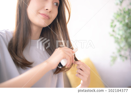 一位女士用直髮器打理頭髮 102184377