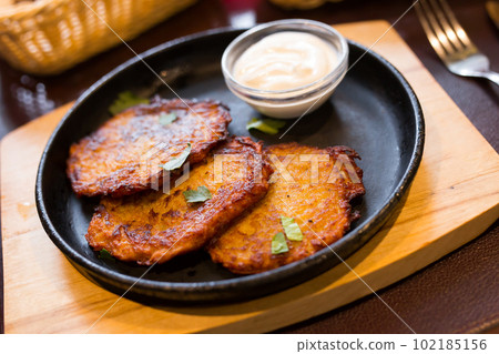 Belarusian cuisine. Appetizing potato draniki stew with sour cream 102185156