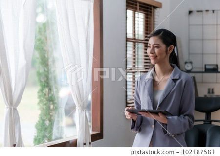 Creative Asian young woman working on laptop in her office. Creative Asian young woman working on laptop in her office. 102187581