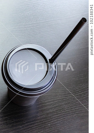 Black paper cup of coffee isolated on wooden table Black paper cup of coffee isolated on wooden table 102188341