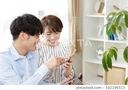 Men and women operating smartphones on the sofa 102190313