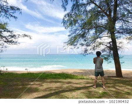 Man stand on sea beach and palms. Tropical vacations concept. 102190432