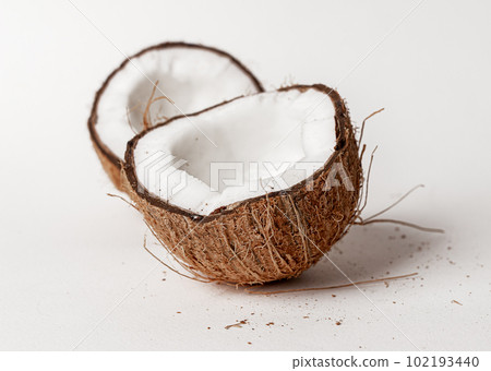 Open broken coconut. Two halves, pieces of coco nut fruit with brown shell Open broken coconut. Two halves, pieces of coco nut fruit with brown shell 102193440