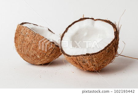 Open coconut. Two halves, cut pieces of coco nut with brown shell and white flesh Open coconut. Two halves, cut pieces of coco nut with brown shell and white flesh 102193442