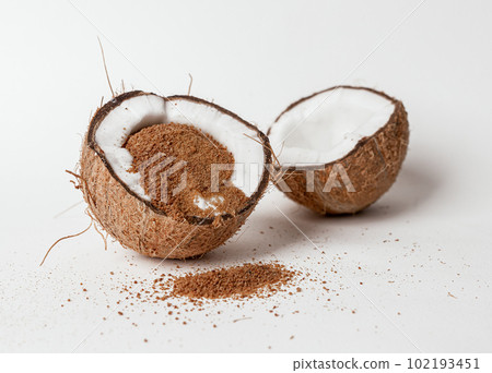 Coco nut sugar, brown organic natural sweet ingredient inside cracked cut coco nut fruit half 102193451