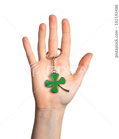 Hand palm holding shamrock, green leaf shaped trinket isolated on white background Hand palm holding shamrock, green leaf shaped trinket isolated on white background 102193486