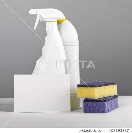 Cleaning concept with paper card mockup and chemical detergents in plastic bottles and washing sponges 102193587