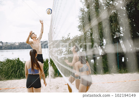 Sports and active life theme. Young players play volleyball. Beach playground. Sports and active life theme. Young players play volleyball. Beach playground. 102194149