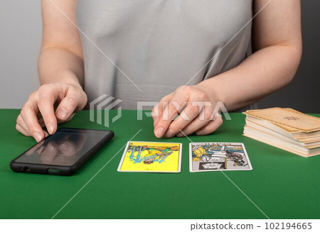 Lodz, Poland March 31 2023 Tarot card reading with mobile app, phone. Modern fortune teller with smartphone 102194665