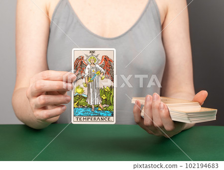 Lodz Poland April 15 2023 Temperance arcana, hand holding showing tarot card during divination 102194683