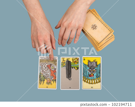 Lodz Poland April 15 2023 hands with three cards spread, tarot for past, present and future telling, destiny predicting, divination 102194711