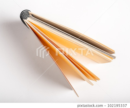 Artists open sketchbook with yellow paper pages for drawing, top view 102195337