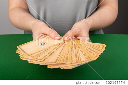 Lodz, Poland April 07 2023 Fortune teller offering tarot cards backside to choose one. Cartomancy, divination concept 102195354