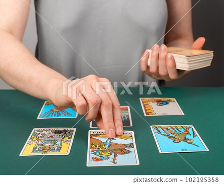 Lodz, Poland April 07 2023 Tarot reader teller spreading playing cards on desk, reading future, fortune Lodz, Poland April 07 2023 Tarot reader teller spreading playing cards on desk, reading future, fortune 102195358