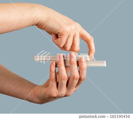 Hand closeup holding tarot deck, cutting part of taro cards, side view 102195438