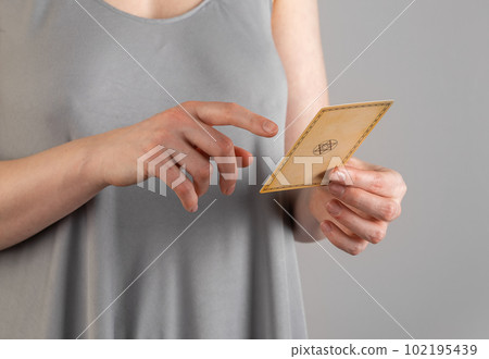 Hand holding abstract tarot card, pointing with finger on it, telling future, fortune, reading meaning 102195439